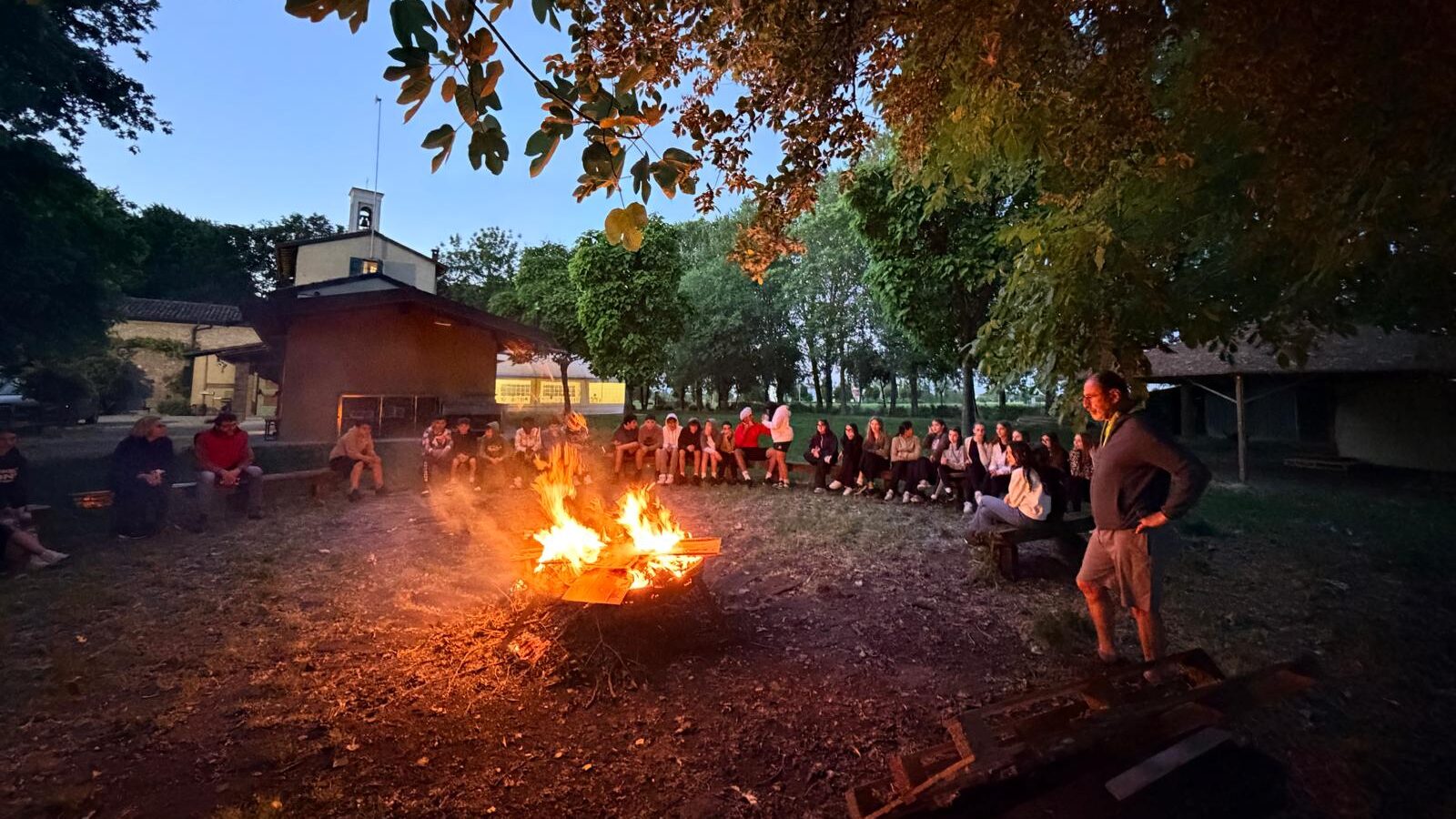 Studenti seduti intorno al fuoco alla base scout di San Vito